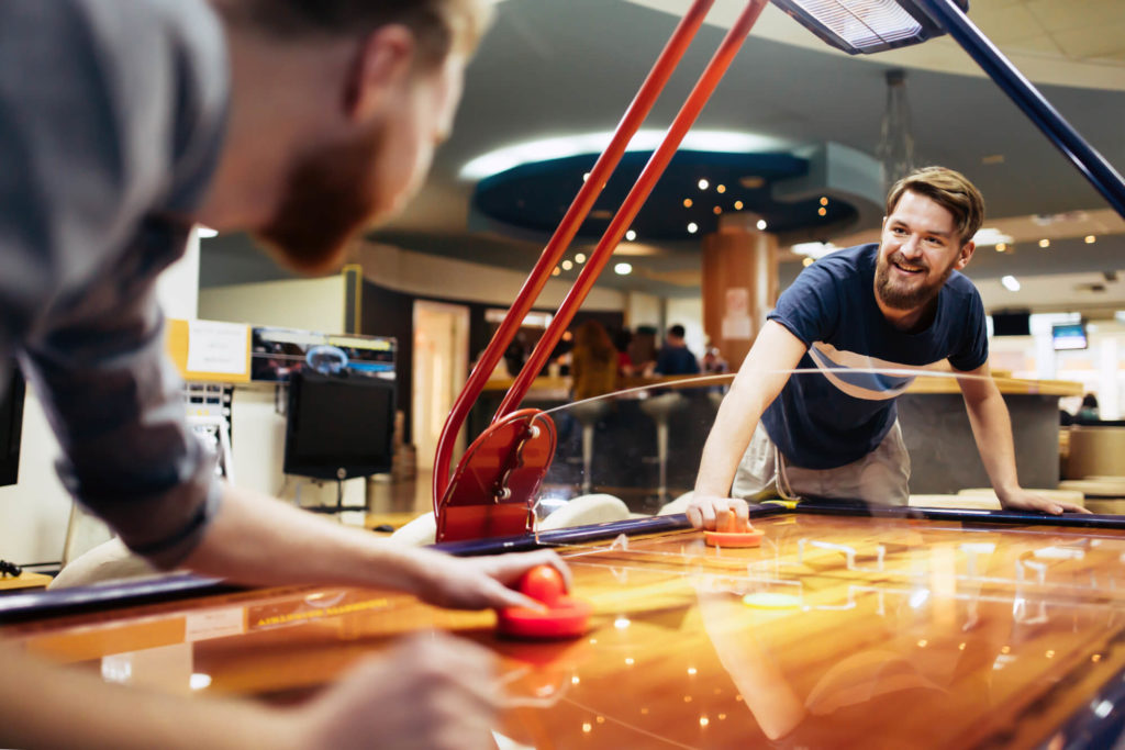 Men playing air hockey