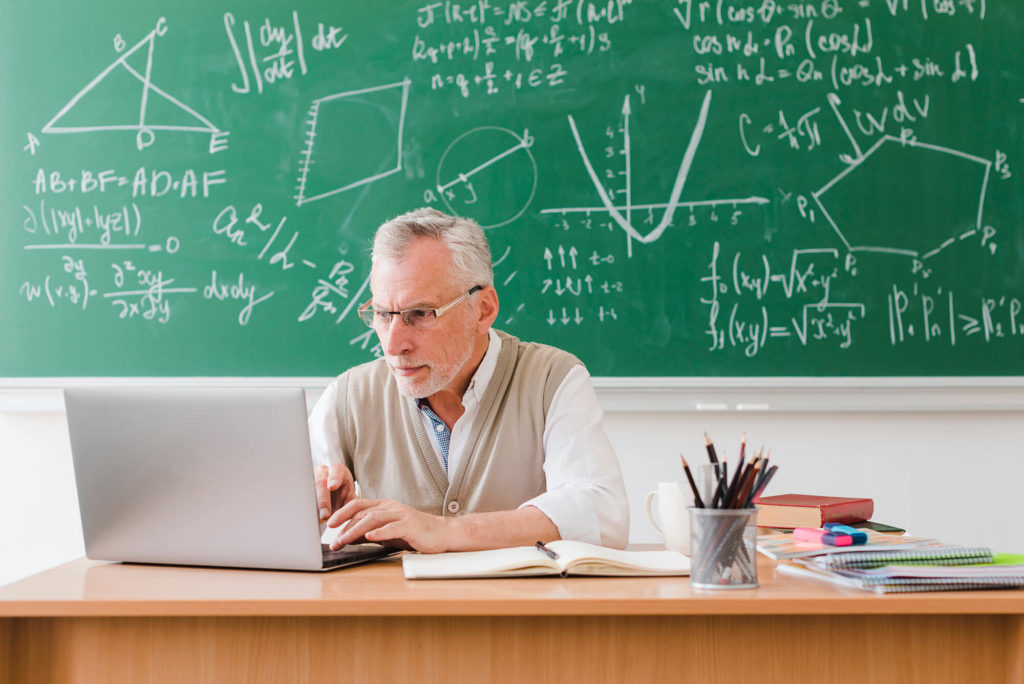 teacher using laptop in classroom