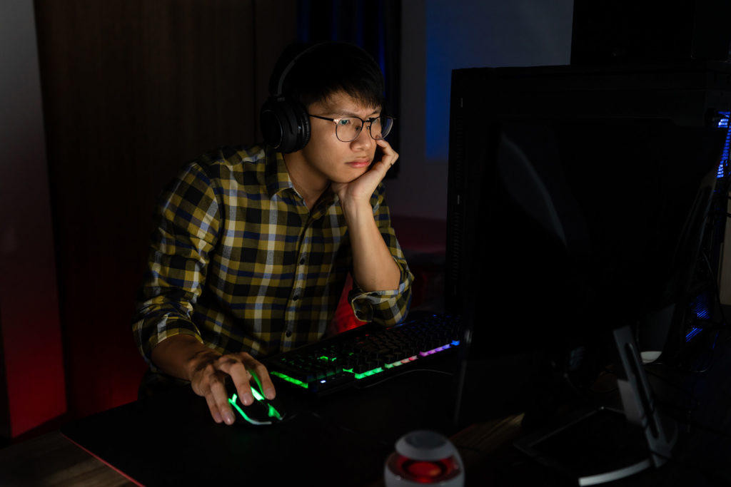 young man playing video game on PC