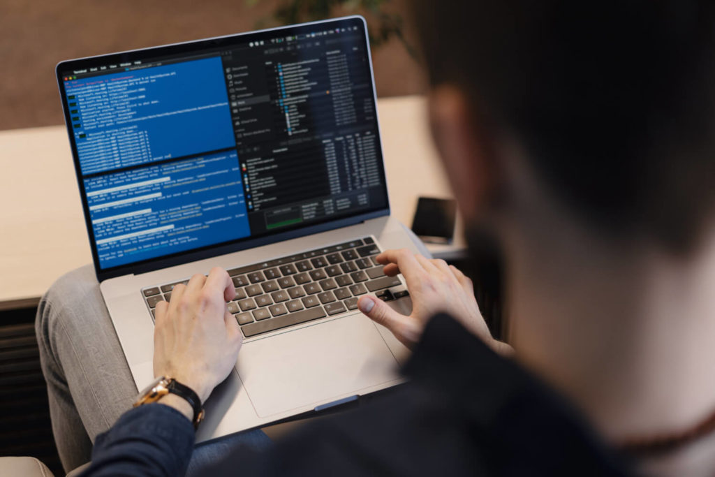 man writing code on a laptop