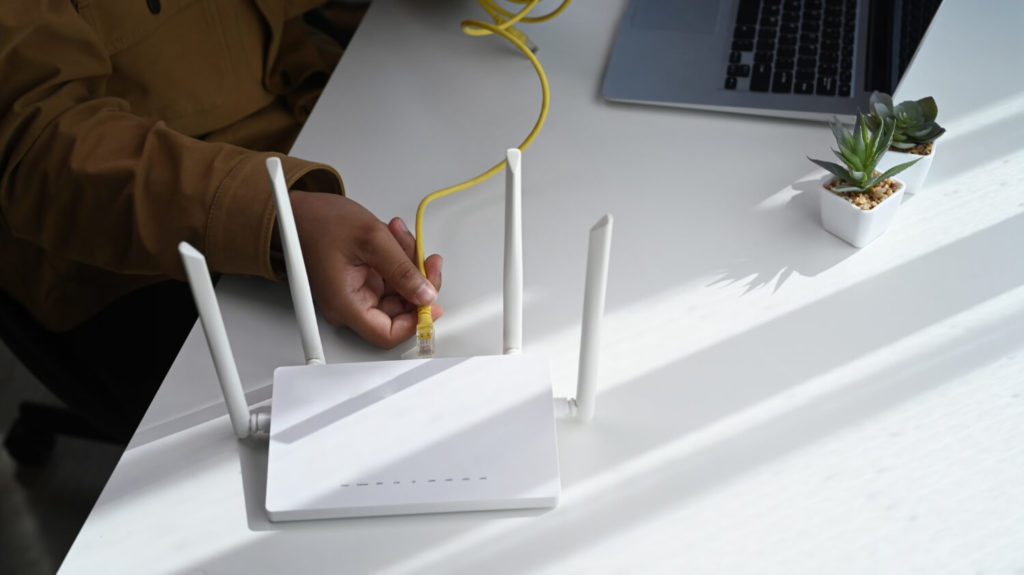 woman inserting cable into router